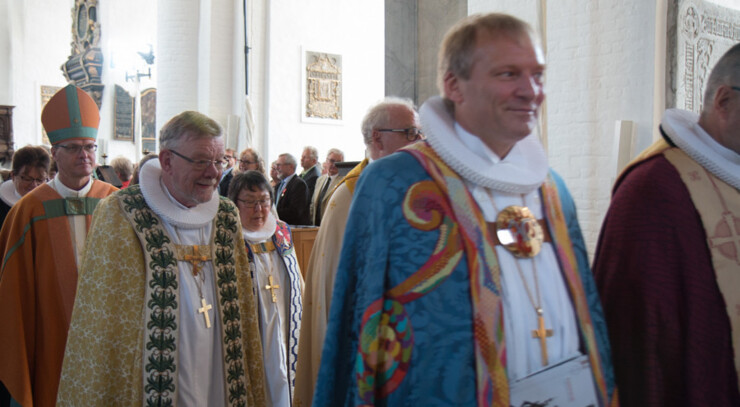 Procession af biskopper i farvestrålende bispekåber.