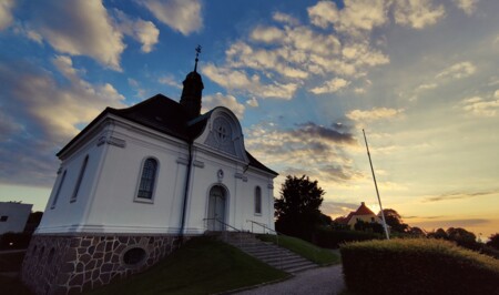 En lille hvid kirke i solnedgang